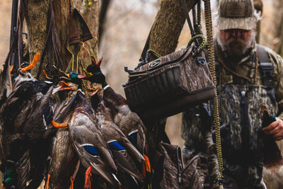 Hunter with harvested mallards, featuring the Tree Hugger Shoulder Bag, showcasing its durable, water-resistant design and spacious storage for hunting essentials.