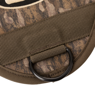 3-Way Duck Tote's olive-drab nylon strap with black metal D-ring attached to camouflage fabric, highlighting its durable design for hunting versatility.