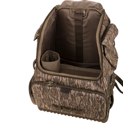 Tree Hugger Timber Pack with open main compartment showing padded dividers, cylindrical insert, various pockets, and exterior zippered front pocket for organized hunting gear storage.