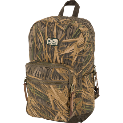 The Waterfowl Throwback 80 Backpack in Mossy Oak Original Shadow Grass features vintage style, front zip pocket, brown zipper pulls, and logo patch—perfect as a rugged laptop backpack.