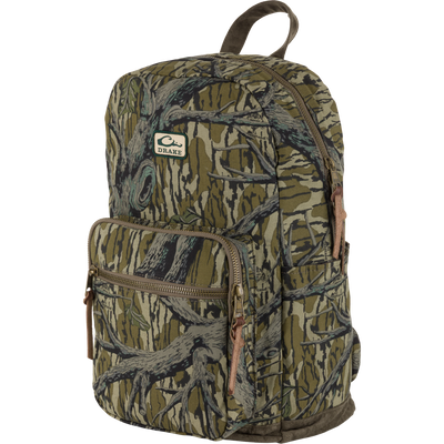 The Waterfowl Throwback 80 Backpack features a Mossy Oak Original Treestand pattern, multiple zippered compartments, cotton canvas construction, and a front Drake logo patch, shown at a three-quarter angle.