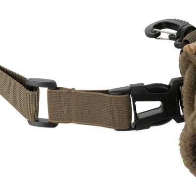 Close-up of a brown adjustable strap with black plastic buckle and clip, attached to fabric—part of the Waterfowl LST Handwarmer Muff—shown against a white background.