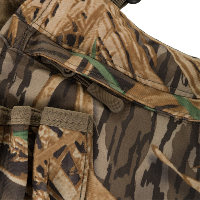 Close-up of the LST Handwarmer Muff by Waterfowl, featuring a camouflage fabric with zipper, stitched pockets, and a waterproof cell phone pocket—ideal for outdoor or hunting use.