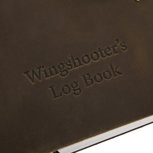 Drake Leather Wingshooter's Hunting Log close-up, showcasing embossed title and durable full-grain leather cover with visible white page edges at the bottom.