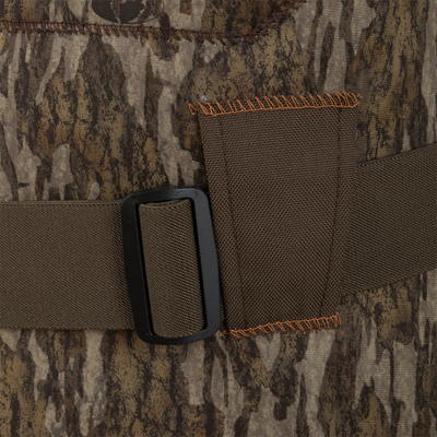 Close-up of an adjustable belt with a black buckle on camouflage-patterned clothing with orange stitching—ideal for pairing with Waterfowl Youth Neoprene Wader gear.