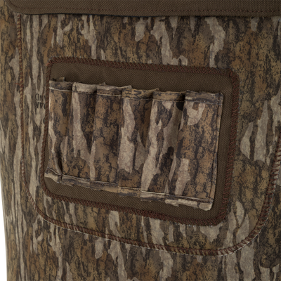 Close-up of a camouflage-patterned pocket with stitched details and flap on the Waterfowl Youth Neoprene Wader, designed for outdoor or hunting use in earth-toned colors.