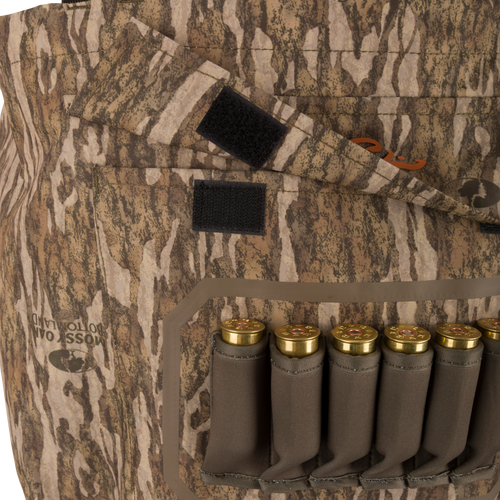 Hardline Uninsulated Breathable Wader with Mossy Oak Bottomland camo, featuring a Velcro flap and built-in ammo carrier loaded with shotgun shells.