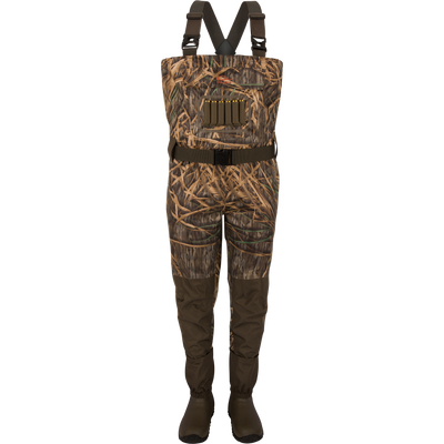 The Waterfowl Hardline Insulated Breathable Wader in Mossy Oak Original Shadow Grass features adjustable suspenders, Thinsulate rubber boots, a waterproof front pocket, and belt—ideal for hunting or fishing.