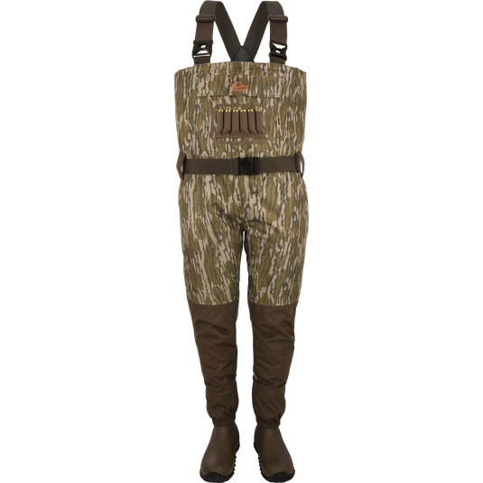 The Waterfowl Hardline Insulated Breathable Wader in Mossy Oak Original Bottomland features attached Thinsulate rubber boots, black adjustable suspenders, a dark belt, and chest loops on a white backdrop.