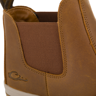 Close-up of a brown Crazy Horse Leather Camp Deck Boot with a brown elastic side panel and a pull tab at the heel.