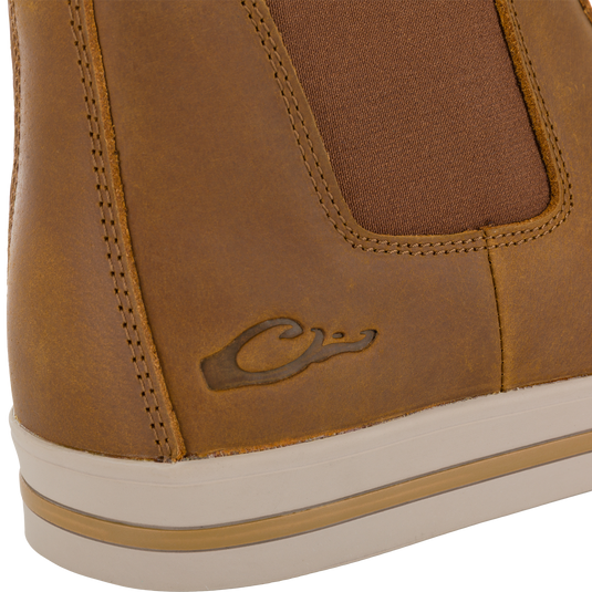 Close-up of a tan Leather Camp Deck Boot with a brown elastic side panel, a rubber sole, and an embossed duck logo on the side.