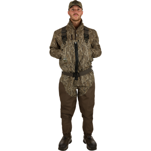 Uninsulated Guardian Elite HND Front Zip Waders: A man wearing waders with Internal handwarmer pockets to keep your hands warm and protected on even the coldest days .