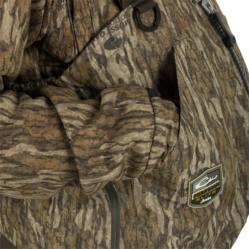 Person wearing the Insulated Guardian Elite HND Front Zip Wader with visible camouflage pattern and logo, highlighting durable construction and reinforced taped seams for hunting.