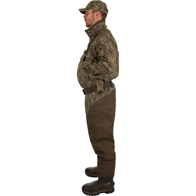 Man wearing Insulated Guardian Elite HND Front Zip Wader in camouflage, showcasing waterproof, breathable fabric, reinforced seams, and Thinsulate® boot lining for hunting durability and comfort.