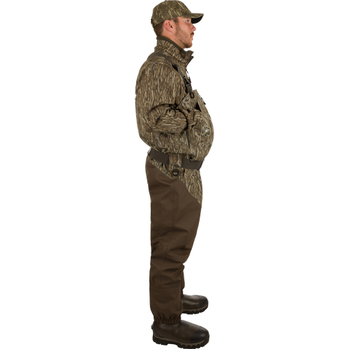 Man wearing Insulated Guardian Elite HND Front Zip Wader, showcasing durable camouflage clothing with reinforced seams and Thinsulate®-lined boots for warmth and comfort in cold weather.