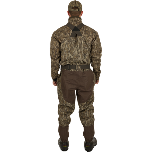 A man wearing the Uninsulated Guardian Elite Vanguard Breathable Waders, designed for extreme conditions, turned to the back.