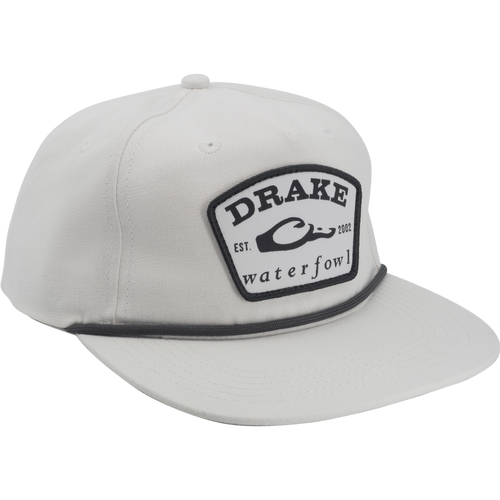Drake X Lost Hat Drake Patch Goat Rope Cap with a stitched shield patch, flat brim, adjustable snap-back, and paracord detail, blending comfort and support.