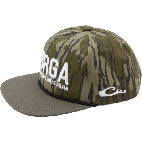 Drake x Lost Hat MBRGA Hybrid Patch Goat Rope Cap featuring camo fabric, flat-brim, white slogan embroidery, and adjustable snap-back closure.