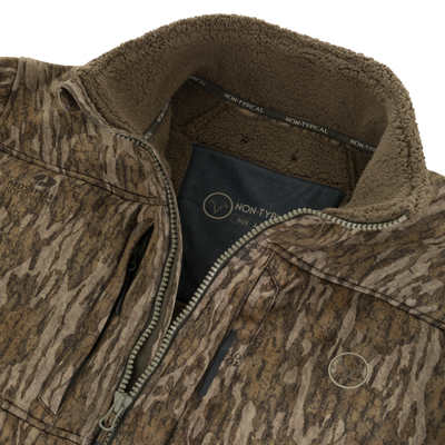 Close-up of the Non-Typical Midweight Nova Silencer Jacket with Scent Control by Nontypical, featuring bark-camouflage, zip front, brown fleece lining, NON-TYPICAL collar branding, and advanced scent control.