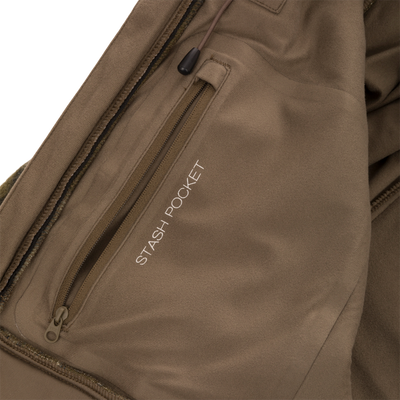 Close-up of a Non-Typical Midweight Hydrowool Softshell Jacket with Scent Control’s inner pocket, labeled STASH POCKET in white text, showing a brown zipper and part of a drawstring.