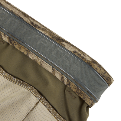 Close-up of the waistband of Non-Typical SWT Pant with Scent Control by Sale, featuring olive green camo, textured fabric, stretch material, and visible stitching.