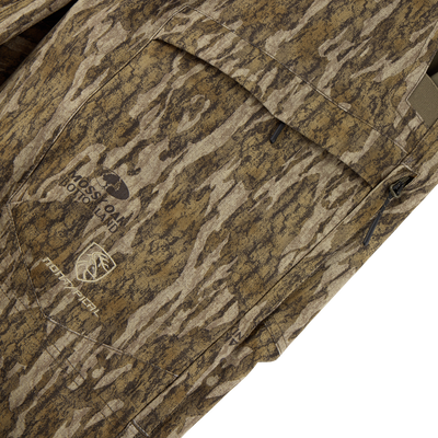 Close-up of camouflage fabric with Mossy Oak Bottomland logo and zippered pocket, made from SWT stretch material—perfect for the Sale Non-Typical SWT Pant with Scent Control, shown against a white background.