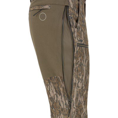 Side view of olive green Non-Typical Pursuit Softshell Pant with Agion Active X2 hunting pants featuring a vertical zippered thigh vent.
