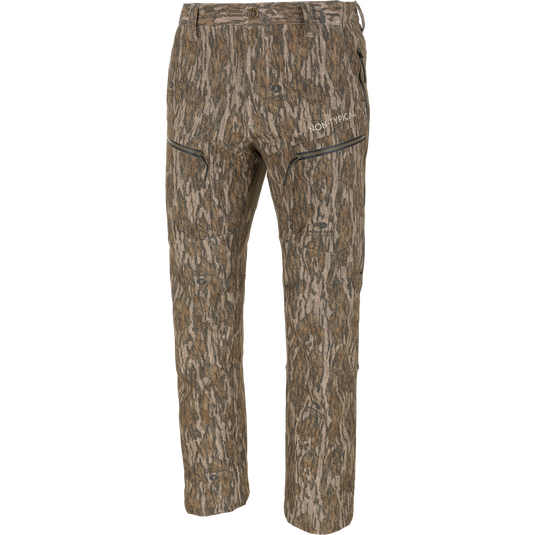 Non-Typical Pursuit Softshell Pant with Agion Active X2 hunting pants in Mossy Oak Bottomland tree bark camouflage, featuring a windproof, water-resistant design with zippered pockets and logo text on the thigh.