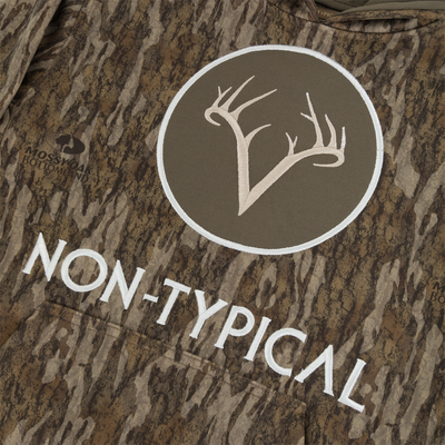 The Non-Typical Youth Performance Hoodie with Agion Active X2 by Nontypical features camo fabric, a white antler logo in a circle, “NON-TYPICAL” text, and the Mossy Oak Bottomland logo on the side.
