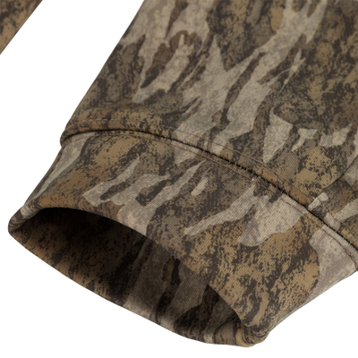 A close-up of the sleeve cuff on the Non-Typical Youth Performance Hoodie with Agion Active X2 by Nontypical, highlighting its brown, green, and tan camouflage fabric treated with Agion Active technology.