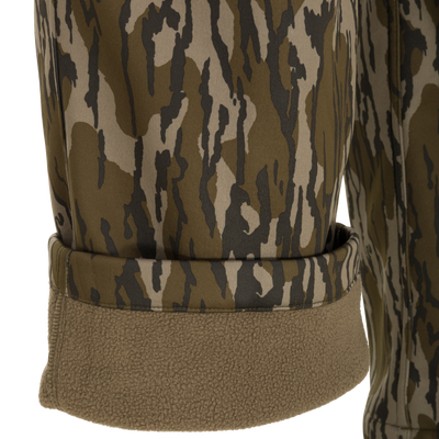 Close-up of the Nontypical Youth Endurance Pant in green and brown camo, featuring a rolled cuff that reveals soft tan fleece lining and advanced scent control technology.