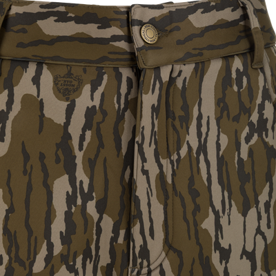Close-up of Nontypical Youth Endurance Pant with brown, green, and black camo, scent control, waistband with belt loop and button closure, plus a subtle left-side logo.