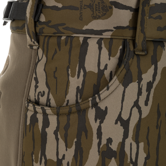 Close-up of Nontypical Youth Endurance Pant pocket showing camouflage pattern in brown, tan, and dark green with visible stitching, belt loop, part of a black belt, and scent control technology.