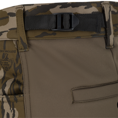 Close-up of Nontypical Youth Endurance Pant in camouflage, featuring a black webbing belt with plastic buckle, pocket, detailed stitching, partial logo near waistband, and microfiber stretch fabric.