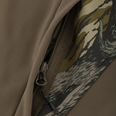 Close-up of a zipper on a solid olive Youth Endurance Full Zip Jacket with Hood, showing a camouflage-patterned fabric lining along the opening.