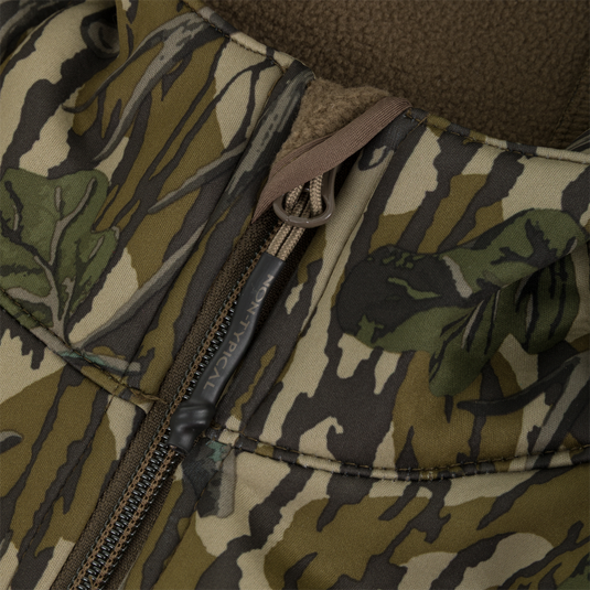 Close-up of a Nontypical Youth Endurance Full Zip Jacket with Hood featuring a green and brown tree bark camouflage pattern with a branded zipper pull.