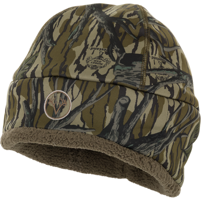 The Non-Typical Silencer Sherpa Fleece Beanie by Nontypical features brown and green tree camo, soft brown sherpa lining, and a front embroidered logo—ideal as a scent control beanie for outdoor adventures.
