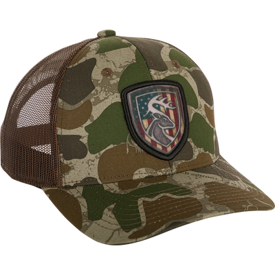 Americana Shield Patch Mesh Back Cap featuring a camo pattern, mesh back, and deer head patch on the front, ideal for outdoor enthusiasts.