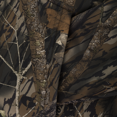 A close-up of the Non-Typical Slacker Quarter Zip Hoodie by Nontypical shows its camo pattern with tree branches and bark in brown, tan, and green—ideal for a cozy, fleece-lined feel.