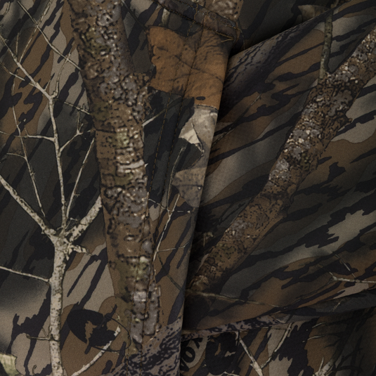 A close-up of the Non-Typical Slacker Quarter Zip Hoodie by Nontypical shows its camo pattern with tree branches and bark in brown, tan, and green—ideal for a cozy, fleece-lined feel.