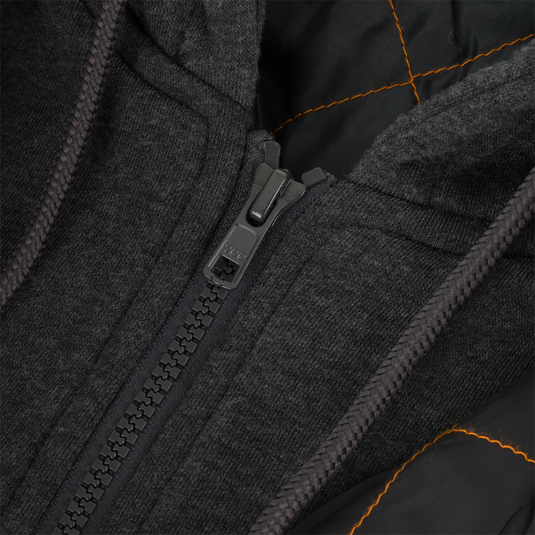 Close-up of the Campfire Canvas Bomber Jacket by Lifestyle: black with a plastic zipper, orange-lined interior, and textured fabric around the zipper and hood for rugged workwear durability.