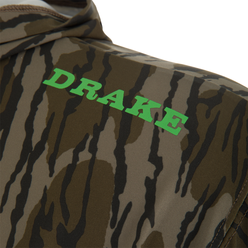 Close-up of Lake Shore Performance Long Sleeve Hoodie, featuring camouflage print with DRAKE in green, showcasing lightweight, moisture-wicking fabric ideal for outdoor activities.