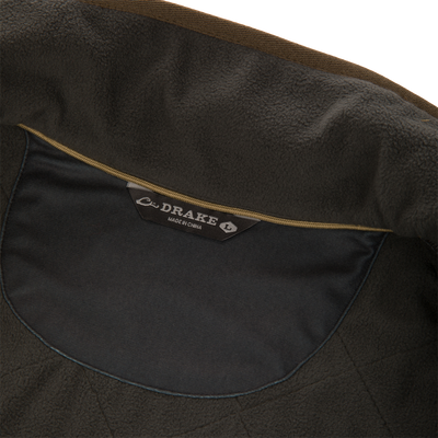Interior view of a dark olive quilted water-resistant Delta Quilted Vest, showing the neck label that reads Drake and Made in China.