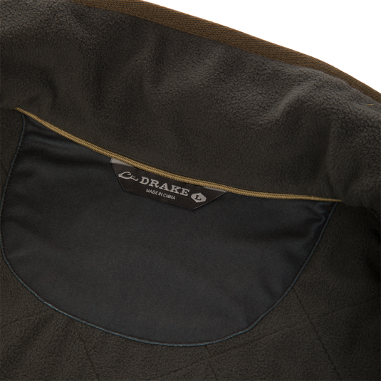 Interior view of a dark olive quilted water-resistant Delta Quilted Vest, showing the neck label that reads Drake and Made in China.