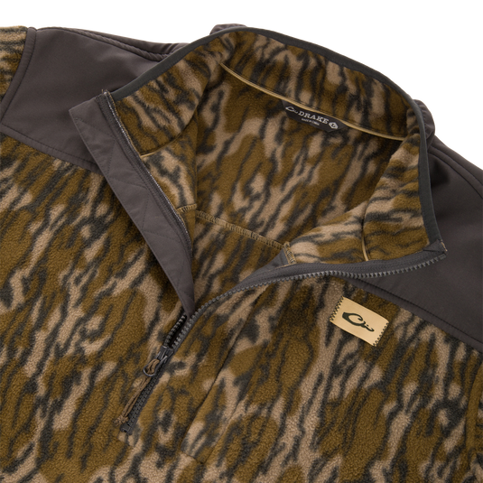 Camp Fleece Over Under Quarter Zip in a brown and green camouflage pattern with solid brown shoulder panels and a logo patch on the chest.