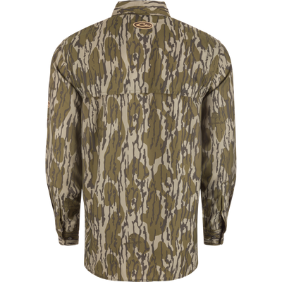 Back view of the Drake Youth Long-Sleeved Flyweight Camo Hunting Shirt in woodland camo pattern, featuring buttoned cuffs and BOTTOMLAND logo near the upper center.