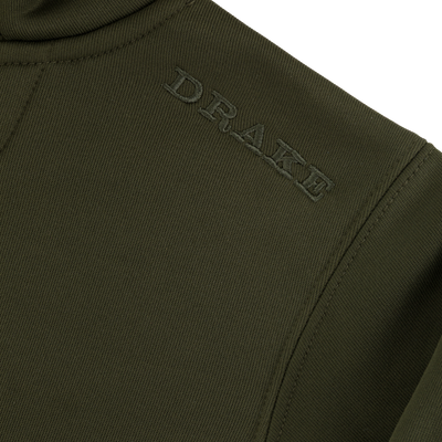 Close-up of olive green, water-resistant fabric on the Youth Back Eddy Limited Edition Hoodie by Sale, featuring DRAKE embroidered in matching green thread near the shoulder seam.