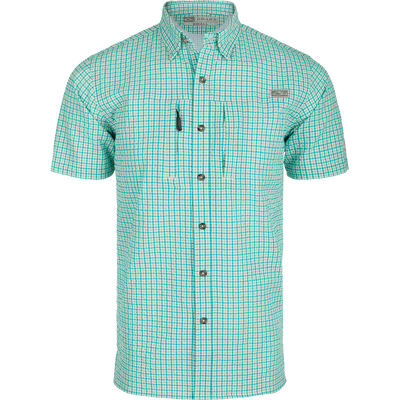 A Classic Seersucker Grid Check Shirt with a hidden button-down collar, zippered chest pocket, and Magnattach™ closure. Made from 76% Polyester and 24% Nylon, it offers UPF30 sun protection and moisture-wicking properties. Vented cape back and split tail hem provide ventilation and versatility. Perfect for hunting, fishing, or casual wear.