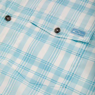 Close-up of the Frat Faded Plaid Button-Down Short Sleeve Shirt, highlighting a button detail, showcasing the lightweight fabric and craftsmanship, ideal for an active lifestyle.