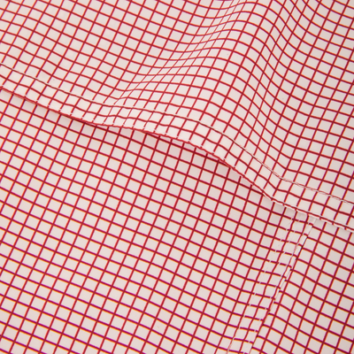 Close-up of Wingshooters Trey Grid Check Short Sleeve Shirt, featuring a fine red grid pattern on lightweight polyester with a stitched seam, highlighting its performance fabric.